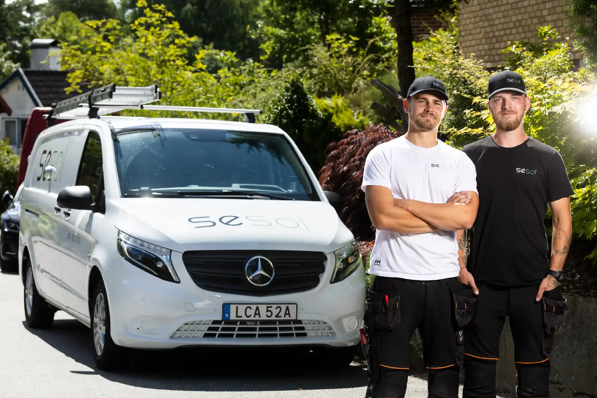 Solcellsmontörer poserar framför Mercedes montörsbil