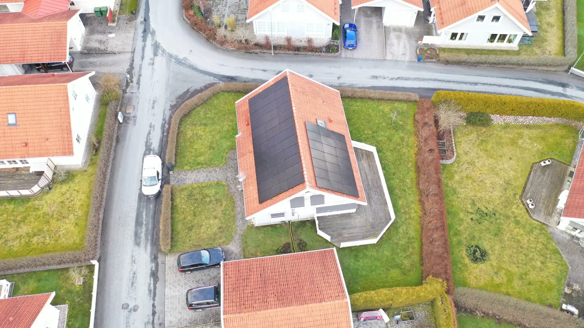 Solcellsanläggning på rött hustak i villaområde
