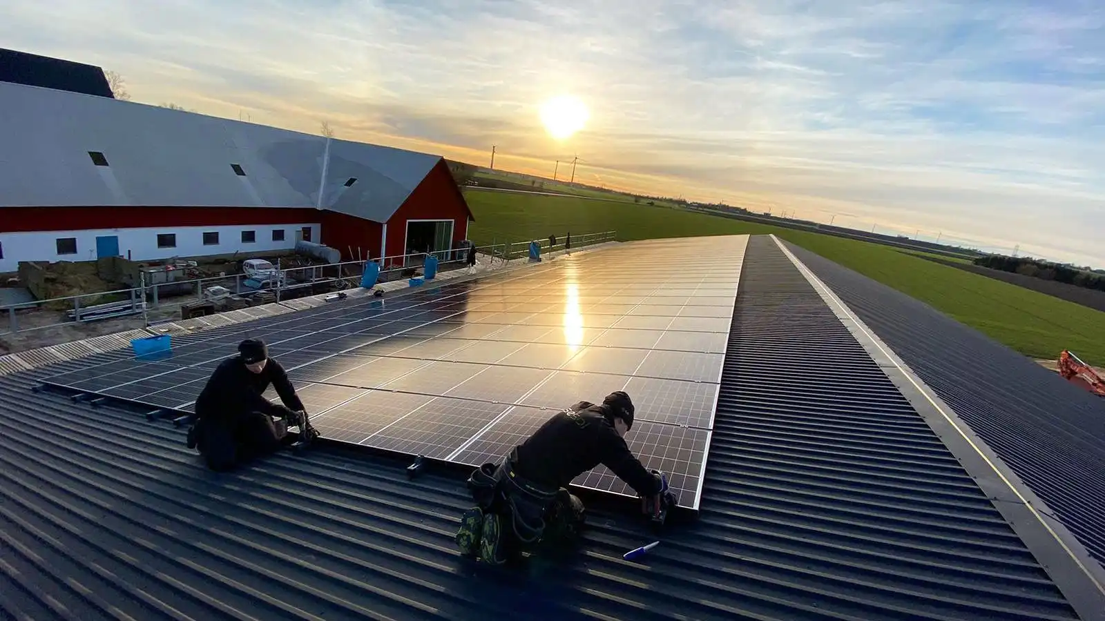 Montörer installerar solceller i solnedgång