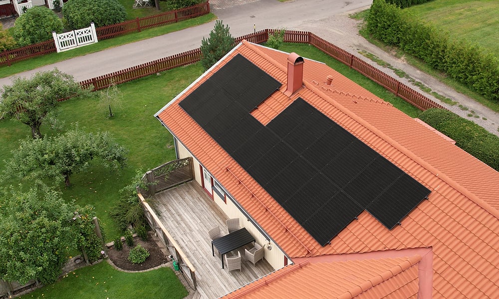 Svarta solceller på rött tegeltak